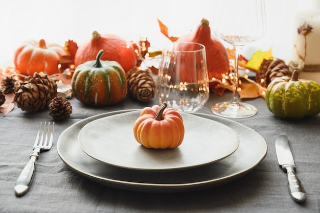 Halloween and thanksgiving day dinner decorated fallen leaves pumpkins spices grey plate