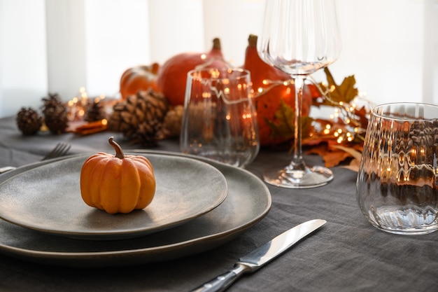 Photo halloween and thanksgiving day dinner decorated fallen leaves pumpkins spices grey plate