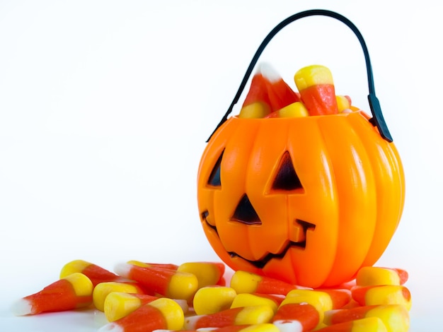 Halloween traktatie tas gevuld met candy corn snoepjes op witte achtergrond.