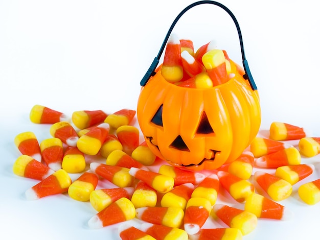 Halloween traktatie tas gevuld met candy corn snoepjes op witte achtergrond.