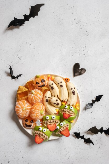 Хэллоуинские угощения из фруктов на тарелке