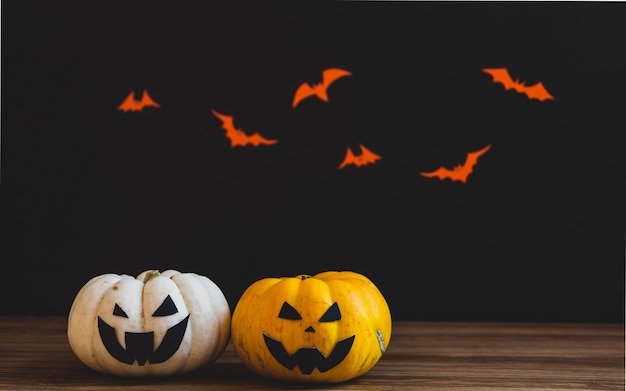 Halloween two pumpkin on wooden table. Black background.