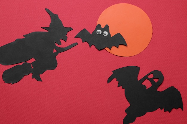 Halloween-vakantie. Compositie met verschillende halloween papieren figuren. uitzicht van boven. op rode achtergrond