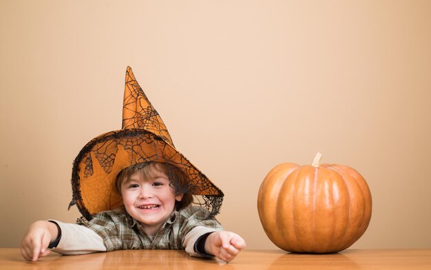 Halloween vakantie concept gelukkig halloween jongetje in heks hoed met pompoen grappige kind jongen in