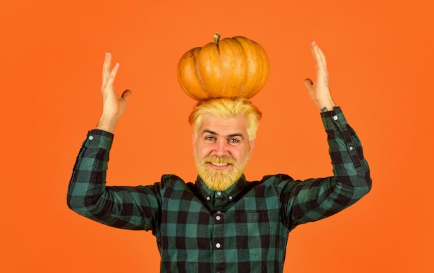 Photo halloween welcome autumn colors of fall season harvest time concept happy farmer with gourd vegetable man retro checkered shirt vintage hipster hold pumpkin and maple leaves