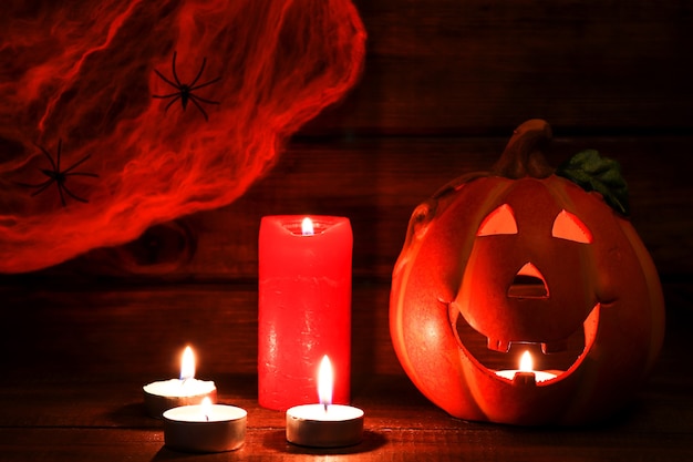 Halloween-wenskaart met Jack-o-lattern, kaarsen en spinnenweb met twee spinnen. Selectieve focus