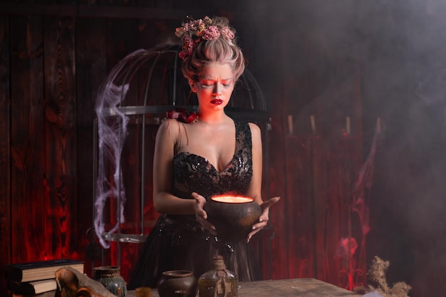 Premium Photo | Halloween witch with cauldron. beautiful young woman  conjuring, making witchcraft. standing spooky dungeon dark room. enchantress  prepare love potion use magic spell