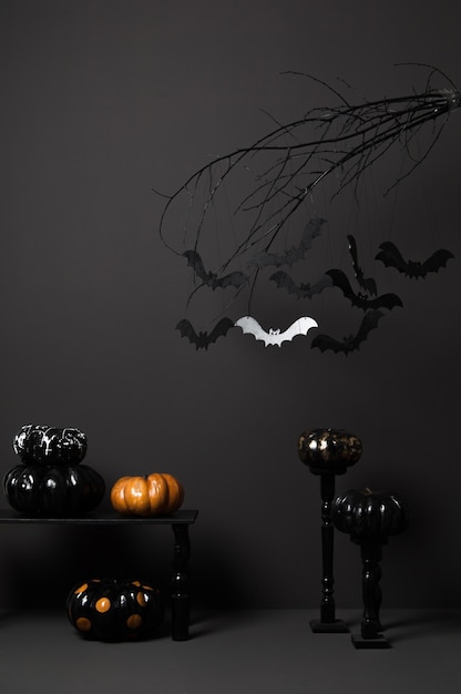 Photo halloween with black bats on a tree and painted pumpkins on a dark background