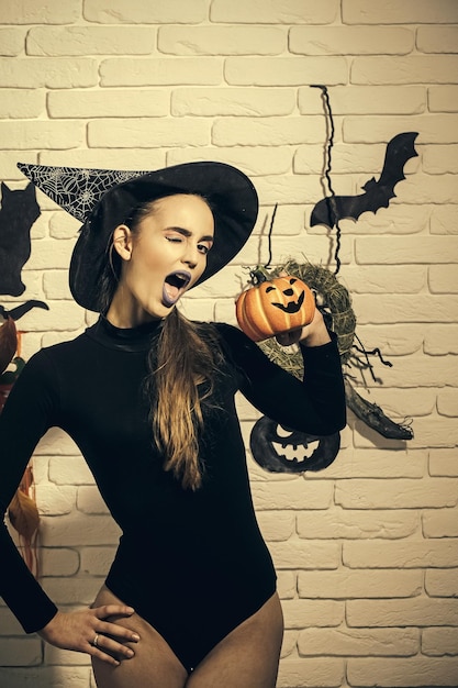 Photo halloween woman winking with blue lips and pumpkin