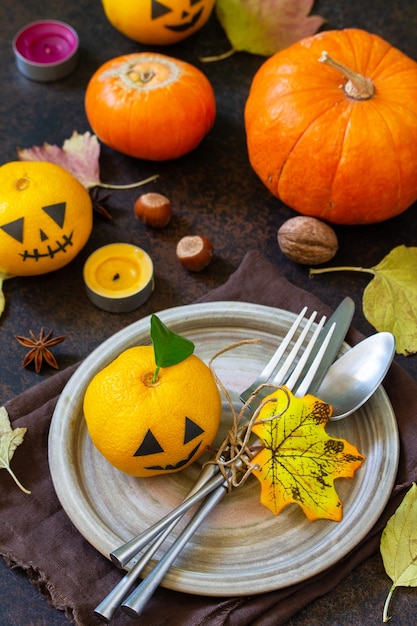 Halloween wooden table setting with pumpkins and tangerines