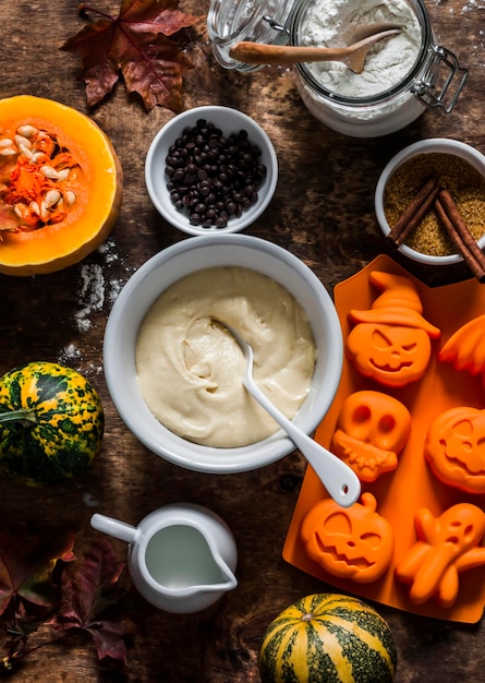 Halloween zoete leuke bakachtergrond Ingrediënten voor het maken van cupcakes op een houten achtergrond bovenaanzicht