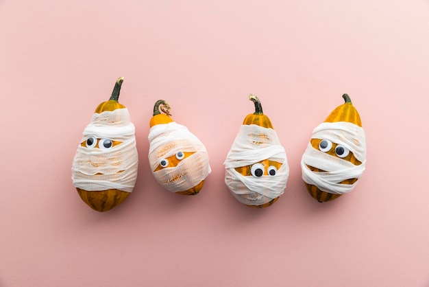 Hallowwen holiday background concept gourd pumpkins dressed as scary mummies with bandages and eyes