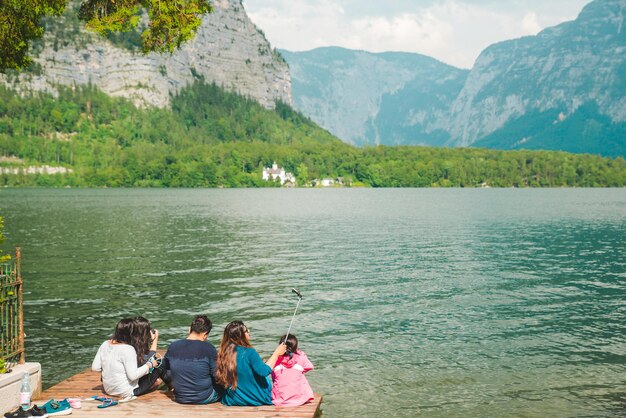 할슈타트 오스트리아 2019년 6월 15일 부두 부두에 앉아 할슈타트 호수를 바라보는 가족