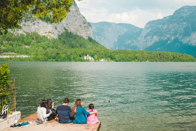 Foto hallstatt austria 15 giugno 2019 famiglia seduta al molo guardando il lago hallstatt