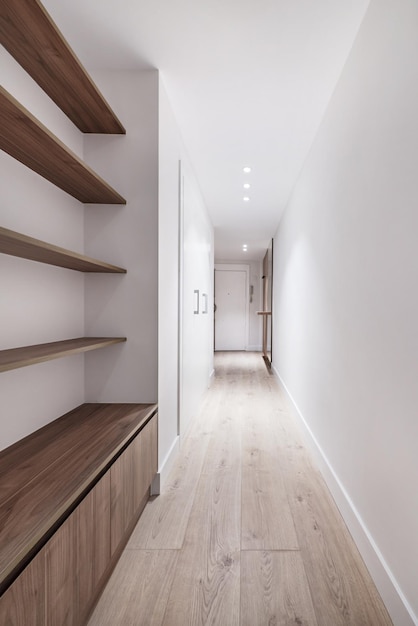 The hallway of a house with cabinets and wooden shelves