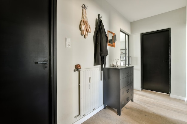 a hallway with a dresser and a black door