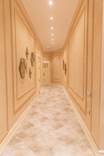 A hallway with gold wall art on the left side and a gold wall art on the right side