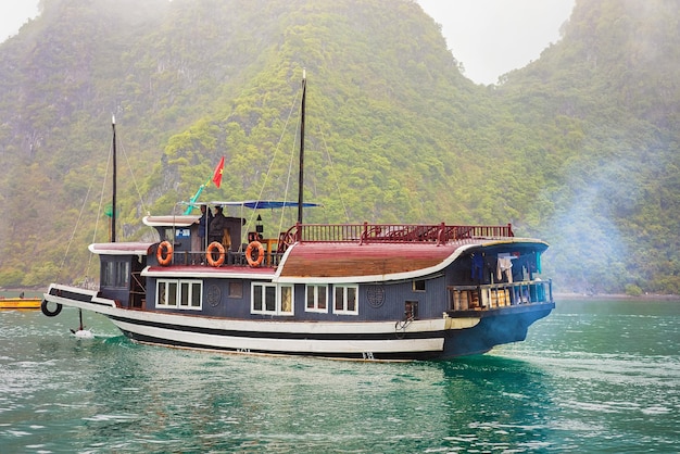 Halong, Vietnam - February 23, 2016: Cruise ship in Ha Long Bay, in Vietnam, Asia. Limestone islands on the background