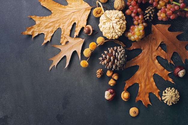 Haloween of thanksgiving compositie met decoratieve pompoen herfstbladeren kegels en druiven bovenaanzicht ruimte voor tekst