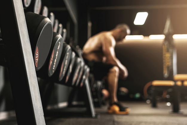 Halters in een sportschool met een vrije ruimte en wazig bodybuilder op achtergrond