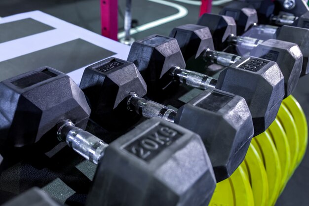 Halters, pannenkoeken en gewichten liggen op de planken. Sportschool. Apparatuur voor gym