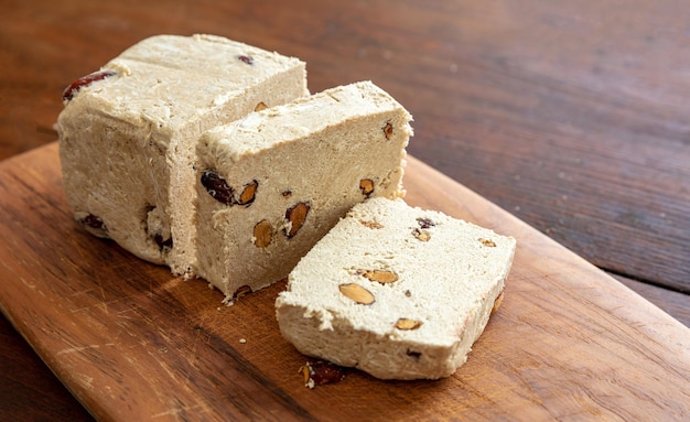 Halva almond nuts slices on wooden table background