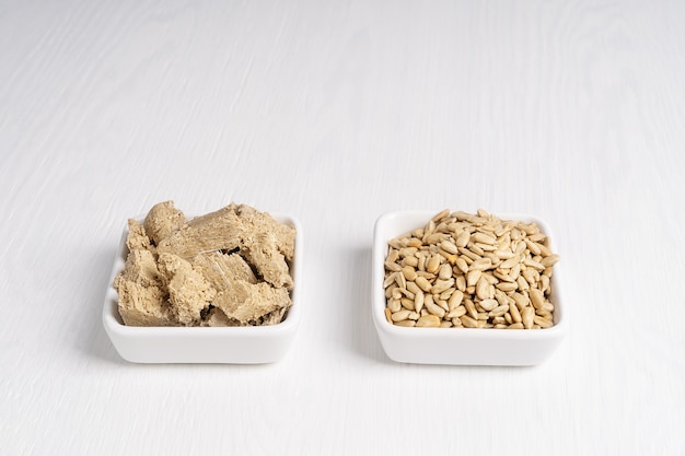 Halva, also halvah, homemade sweet dessert and sunflower seeds served in two square plates