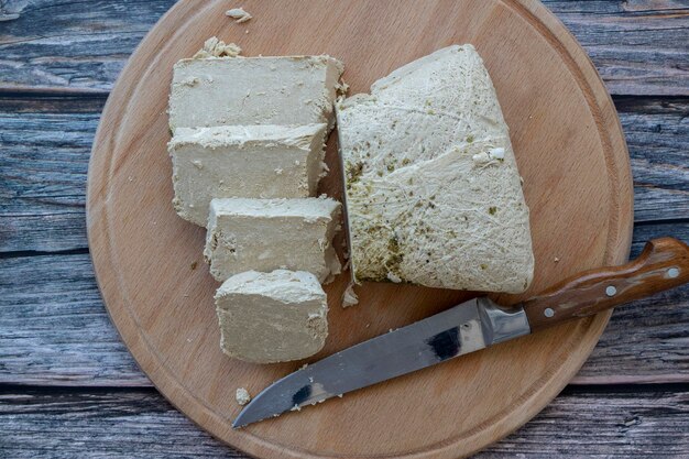 Foto pezzi di semi di girasole halva su sfondo tavolo in legno, vista ingrandita. halvah alla vaniglia o halwa, dolce tradizionale a base di tahin di sesamo