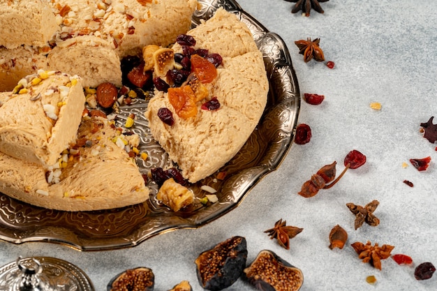 Halva with dried fruits on arabic dishware