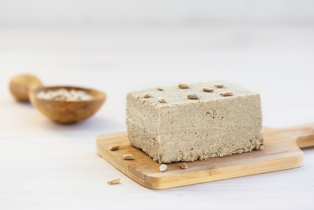 Halva with sunflower seeds on a wooden board