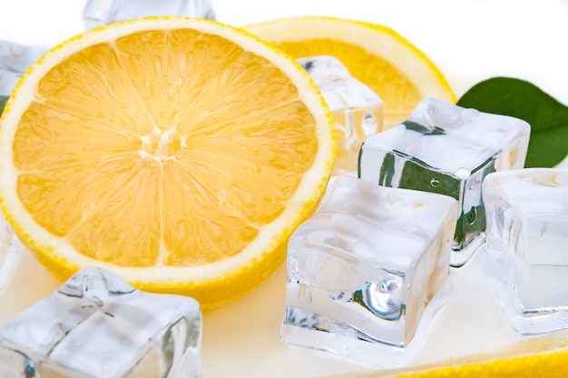 Halve sappige heldere citroen en verfrissende ijsblokjesclose-up