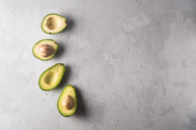 Foto avocado diviso in due su sfondo grigio. concetto di mangiare sano con copia spazio