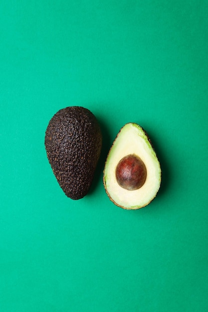 Halved avocado with green background