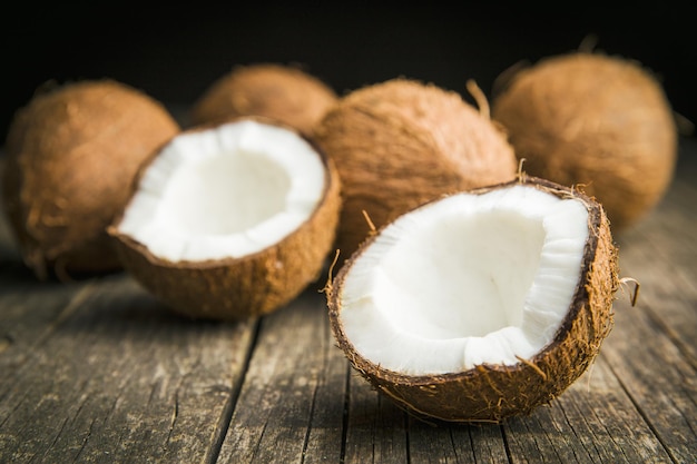 The halved coconuts on old wooden table