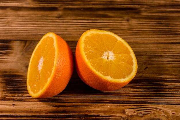 Halved orange fruit on rustic wooden table