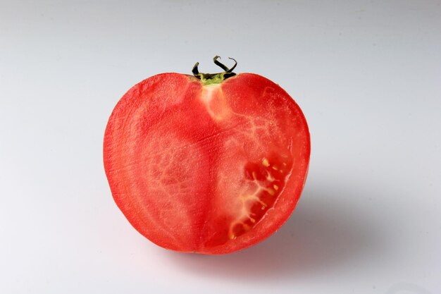 halved red tomato on a white background. sliced ripe tomato