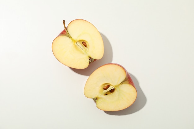 Halves of apple on white table