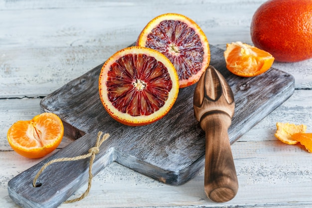 Halves of blood orange and citrus press