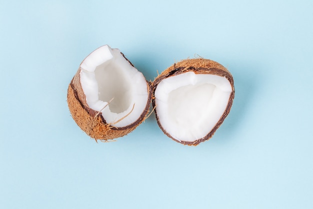 Halves of chopped coconut on blue background