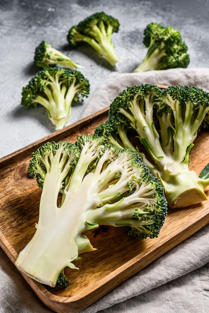 Halves of fresh broccoli in a wooden bowl. Gray background. Top view