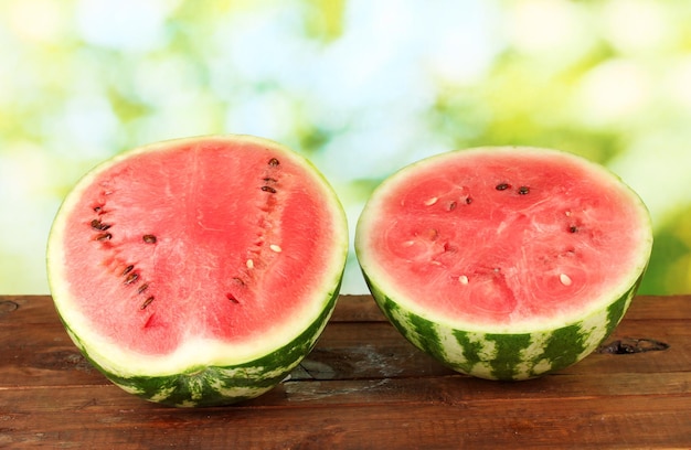 Halves of juicy watermelon on green background closeup