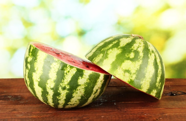 Halves of juicy watermelon on green background closeup