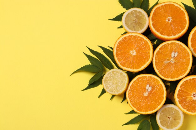 Halves of lemons and oranges with green leaves