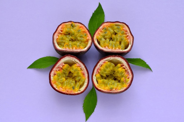 Halves of passion fruit on lilac background