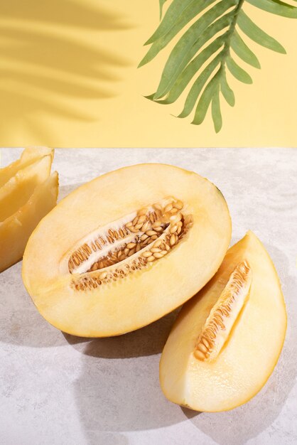 Halves of ripe juicy melon on yellow background in sunlight, summer food.