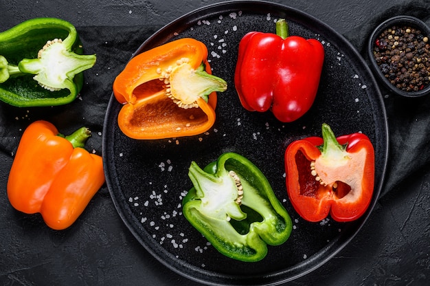 Halves of sliced orange, green and red bell peppers. Top view