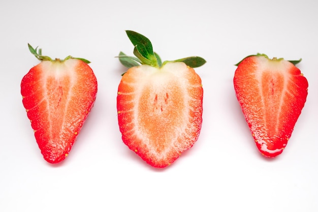 Halves of sliced strawberries on a white background