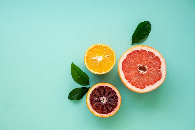 Halves of various citrus fruits on a blue background