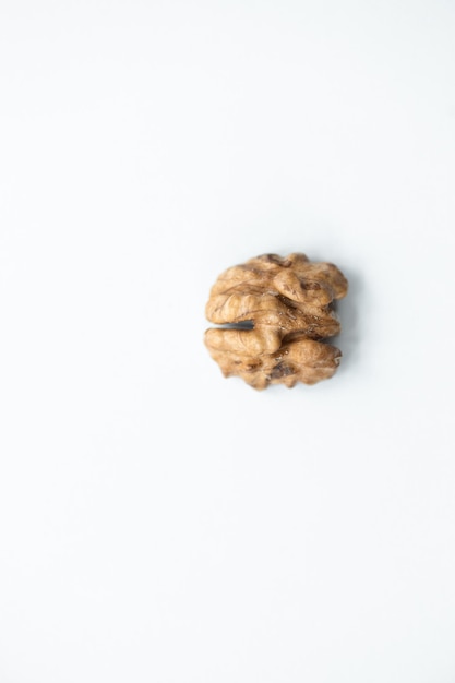 Halves of walnuts on white background pattern top view