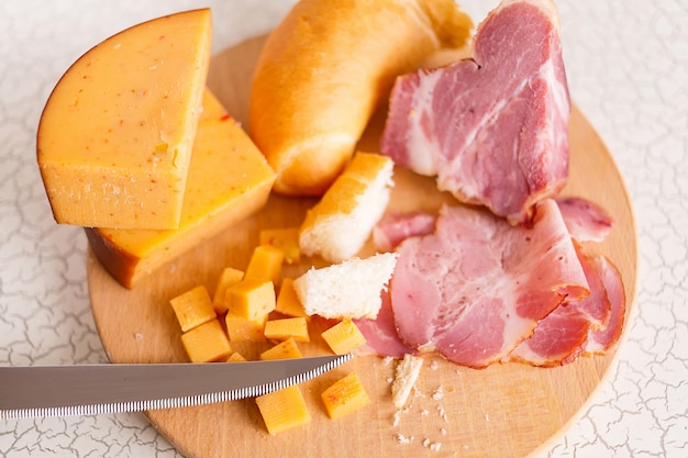 Ham, cheese and bread on a wooden cutting board